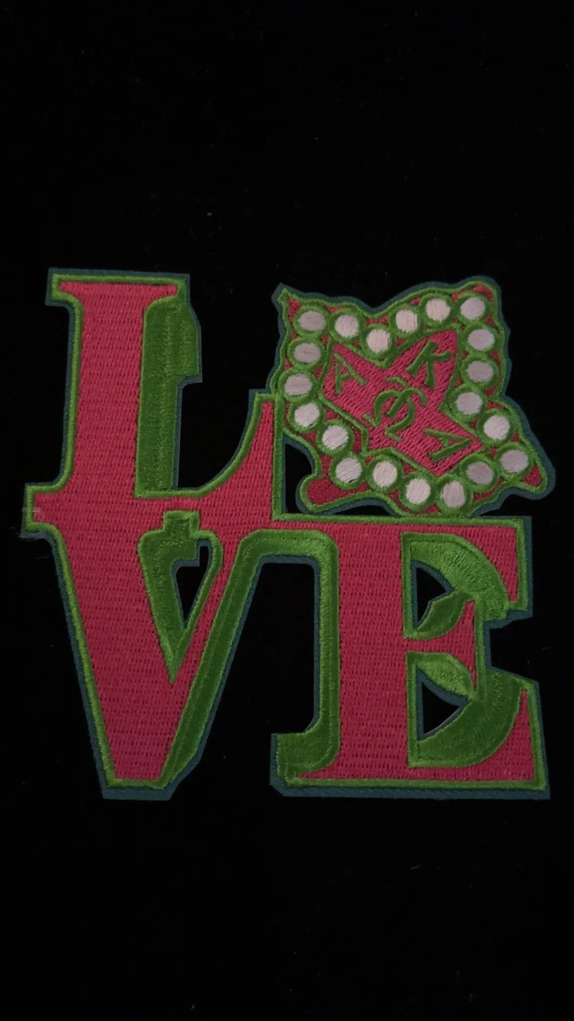 AKA-inspired embroidered LOVE patch in pink and green with pearl shield, ideal for sorority fashion, DIY gifts, and Greek pride accessories.