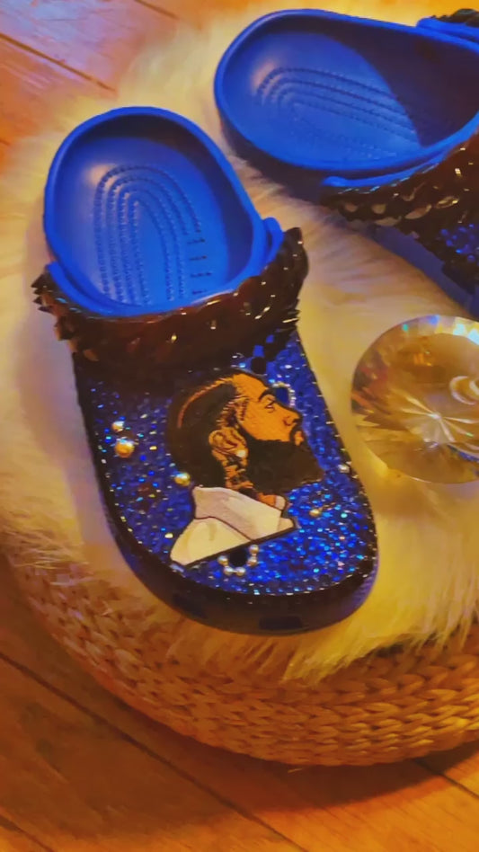 Step into Nipsey Hussle's legacy with our Blue Crocs. Featuring a Nipsey Hussle patch and iconic Jibbitz, these Crocs pay homage to the legendary artist. The sleek blue design and chic black accents add urban style to comfort. 🎵👟🌟 #NipseyHussle #CustomCrocs #FashionFootwear - Video